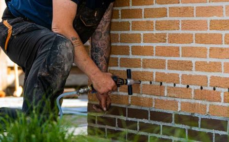 Un expert en humidité de Murprotec injecte un produit hydrofuge dans un mur contre l’humidité ascensionnelle