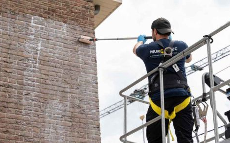 Un expert en humidité de Murprotec imprègne la façade pour la protéger de l’infiltration d’eau